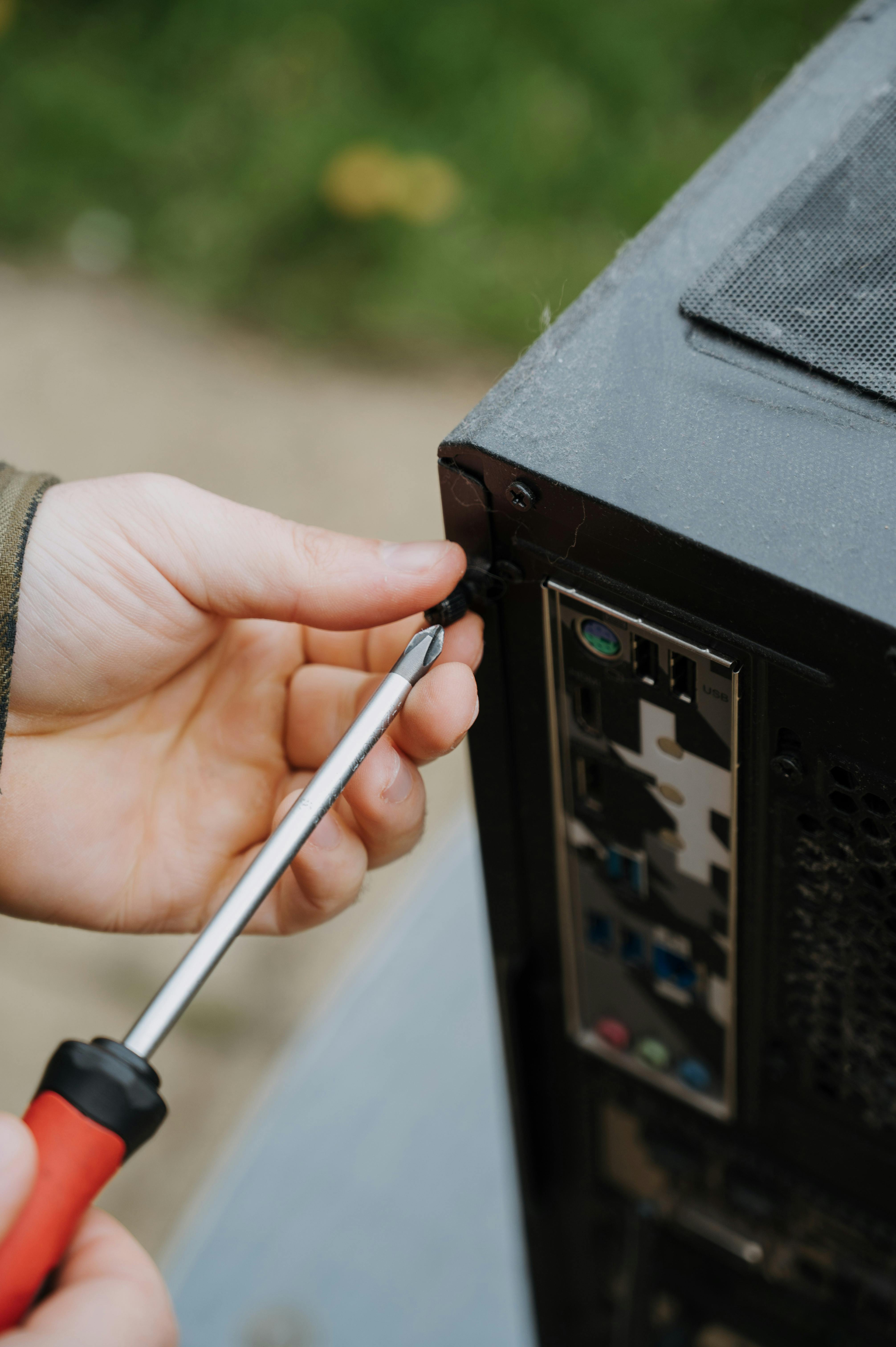 Close-up of a technician repairing and tightening components inside a desktop computer